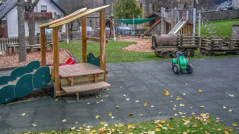 Duży naturalny plac zabaw w Olsbergu, wykonany z szarych płyt WARCO, zapewnia dzieciom atrakcyjną i bezpieczną zabawę dzięki nawierzchni amortyzującej upadki.