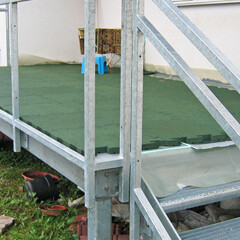 Zielone płyty balkonowe WARCO są układane na stalowej kracie tworzącej podłogę balkonu.
