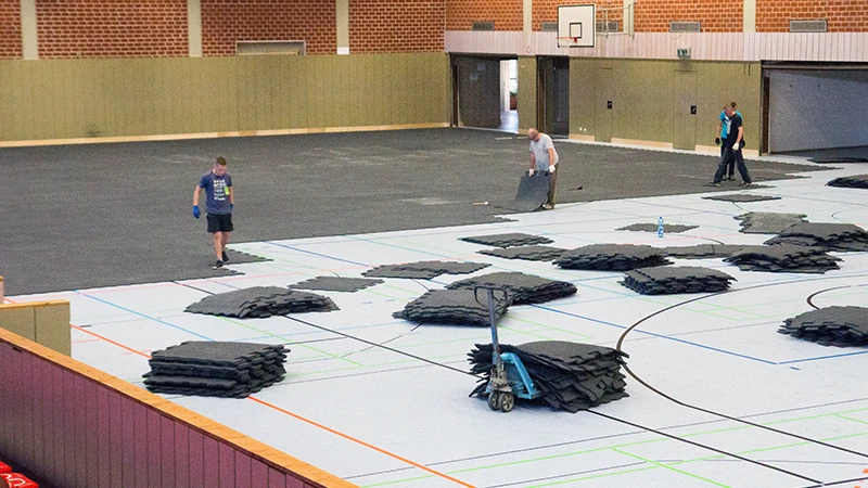 Podłoga wystawowa WARCO została położona w dużej hali sportowej. Są to maty z granulatu gumowego typu puzzle. Podłoga eventowa chroni delikatną podłogę sportową hali przed uszkodzeniem.