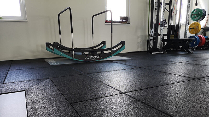 Strefa cardio z maszynami w siłowni jest wyposażona w czarne płyty sportowe WARCO z granulau gumowego.