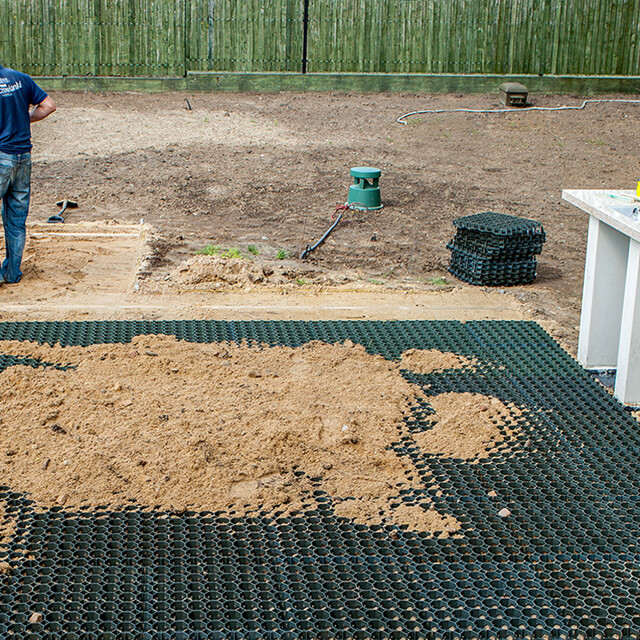 Montaż plastikowych kratek stabilizujących grunt od WARCO w ogrodzie, na podłożu niezwiązanym i wypełnionym piaskiem.