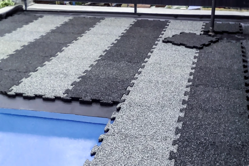 Stary betonowy przydomowy basen jest w trakcie renowacji, jego otoczenie jest pokrywane nowymi, antypoślizgowymi płytami basenowymi WARCO w kształcie puzzli, w jasnym i ciemnym granicie.